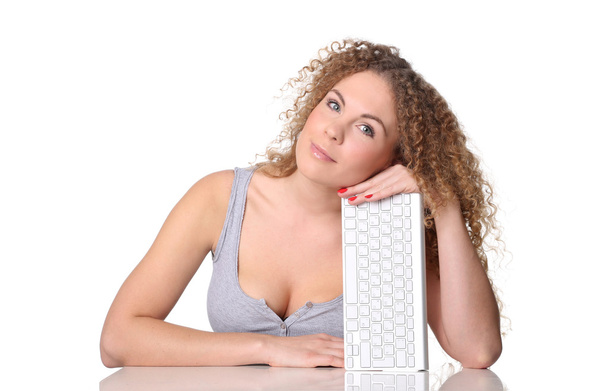 Beautiful woman, red curly hair, sitting at a desk with keyboard - Zdjęcie, obraz