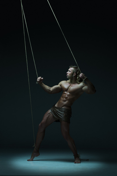 Young naked man, muscular body, bounded with rope - Foto, imagen