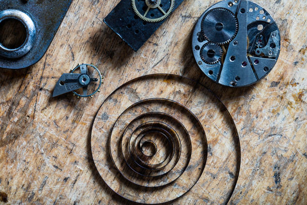 spring, balance wheel and clockworks on a table - Photo, Image