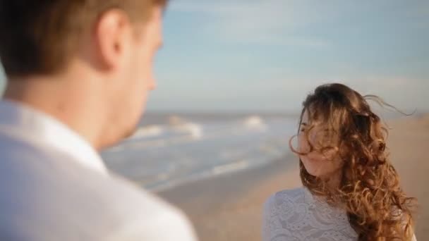 Mężczyzna pocałunek womans ręce na plaży - Materiał filmowy, wideo