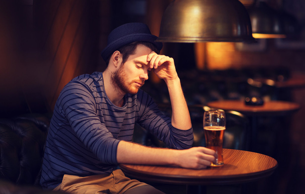 unhappy lonely man drinking beer at bar or pub - Φωτογραφία, εικόνα