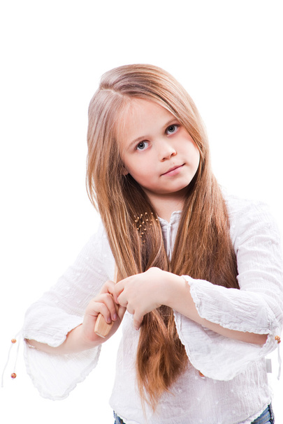 Cute girl combing fine long blond hair on isolated white - Photo, Image