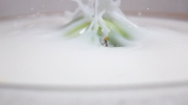 Green apple falling into the milk - Footage, Video