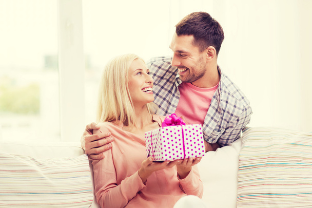 happy man giving woman gift box at home - 写真・画像
