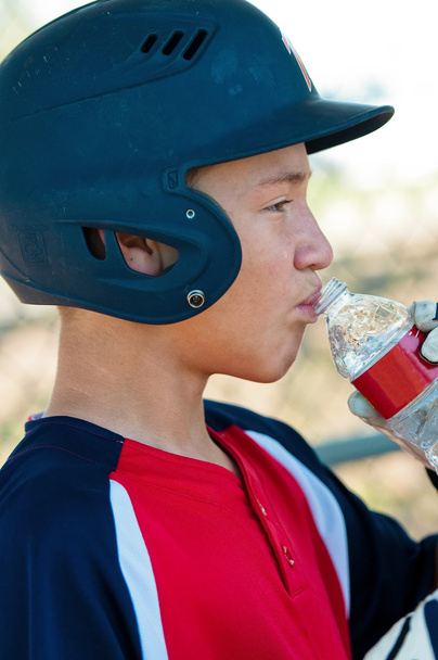tiener honkbal speler drinkwater - Foto, afbeelding