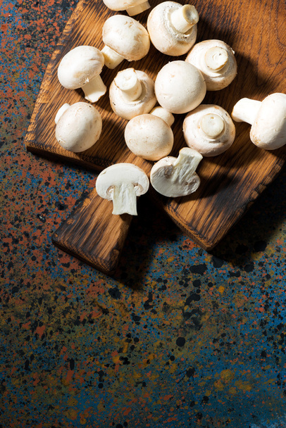 cogumelos orgânicos frescos na placa de corte vintage, vertical
  - Foto, Imagem