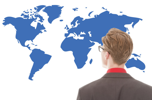Nuori liikemies katselee sinistä maailmankarttaa eristyksissä valkoisella taustalla
 - Valokuva, kuva