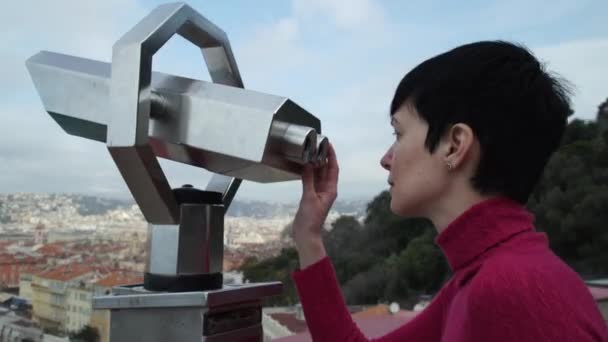Touristin steht auf der Aussichtsplattform und blickt durch ein Teleskop. - Filmmaterial, Video