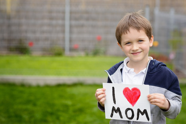  7-jähriger Junge mit einer Grußkarte für seine Mutter  - Foto, Bild