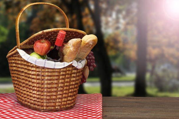 Piknik sepeti yiyecek ve içecek ahşap masa üzerinde ile - Fotoğraf, Görsel