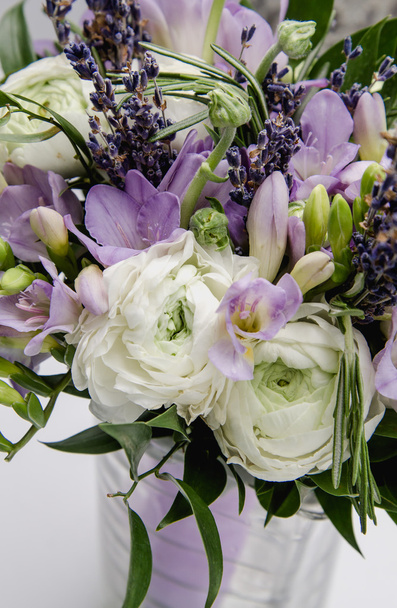 Moderni kaunis kimppu leinikki ranunculus, fresia, laventeli kukkia valkoisella taustalla. Häät tyyli käsite. Asetelma, maalaismainen. Morsiuskimppu. Avioliitto
. - Valokuva, kuva