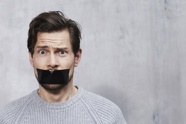 man with tape over mouth - Φωτογραφία, εικόνα