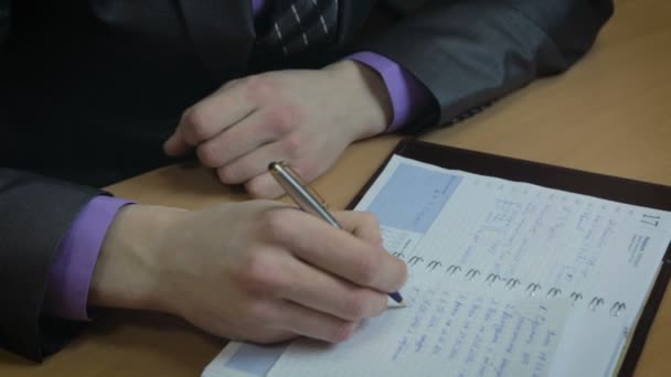Businessman working in office. He wrote in the diary. - Video, Çekim