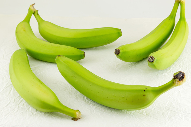 Zielone banany na biały włókienniczych - Zdjęcie, obraz