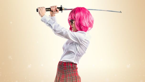 刀を保持しているピンクの髪の少女 - 写真・画像