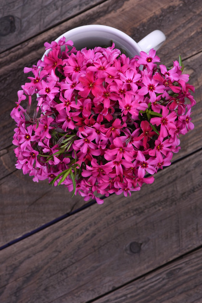 Bouquet de fleurs roses printanières sur planche en bois
 - Photo, image