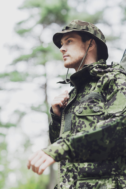 young soldier or hunter with gun in forest - Фото, изображение