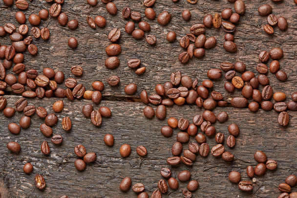 Coffee beans scattered on wooden table - Fotografie, Obrázek