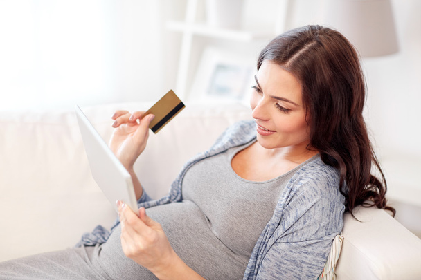 pregnant woman with tablet pc and credit card - Foto, afbeelding