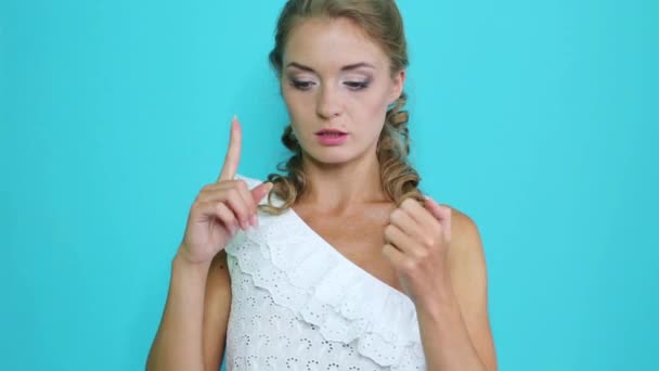 Young girl lists and bends her fingers near the blue wall - Imágenes, Vídeo