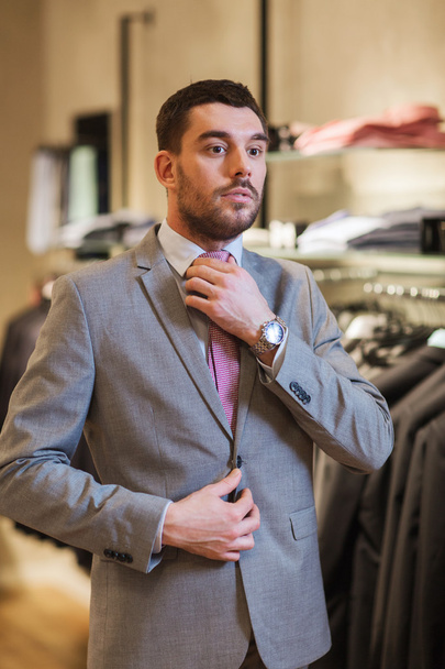 young man trying suit on in clothing store - Foto, immagini