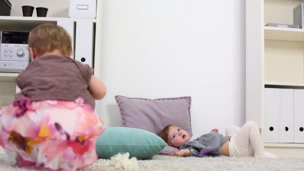 Little girl play with box of beads and her friend lies on carpet - Πλάνα, βίντεο