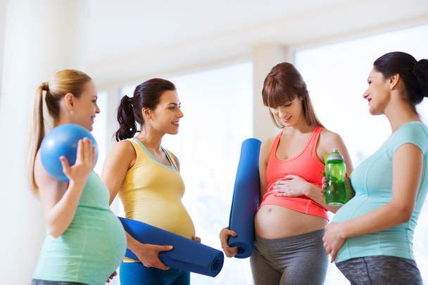 group of happy pregnant women talking in gym - Fotó, kép
