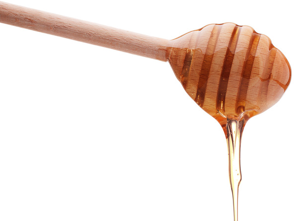 Honey dripping from wooden dipper - Фото, зображення