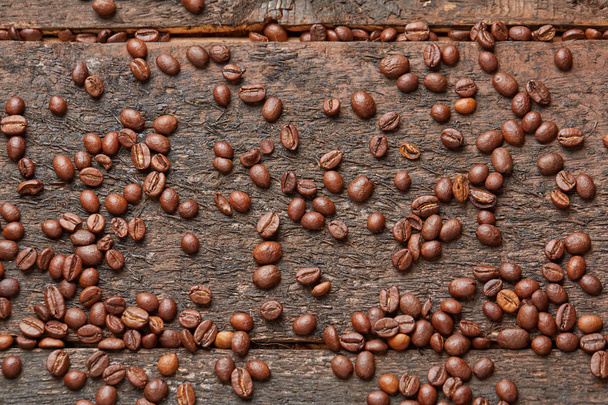 coffee beans scattered on the wooden table - Φωτογραφία, εικόνα