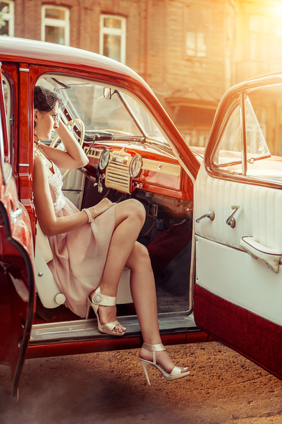 Гарненька жіноча вуаль сидить у старовинній машині
.  - Фото, зображення