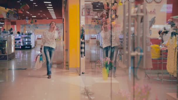 Boldog vásárlás nő a shopping Center, a smartphone beszélő. - Felvétel, videó