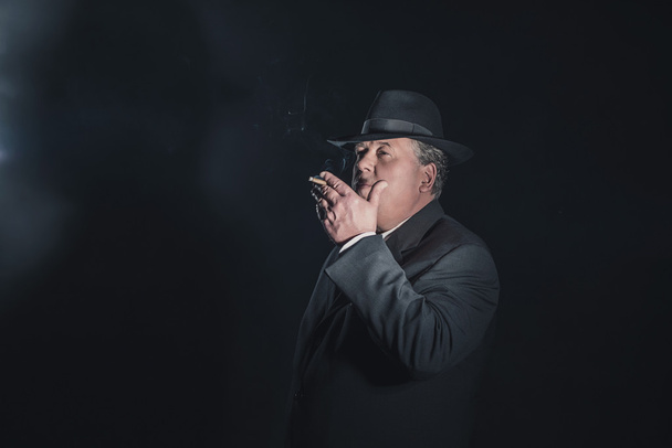 Gangster im Retro-Look der 40er Jahre raucht Zigarre.  - Foto, Bild