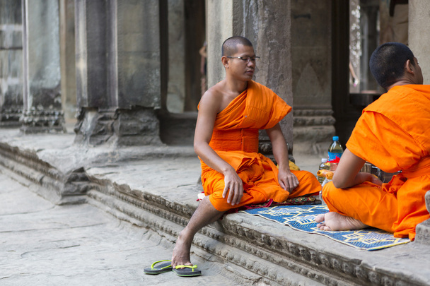 Cambodian monks sitting on stairs at Angkor Wat temple, Cambodia - Foto, imagen