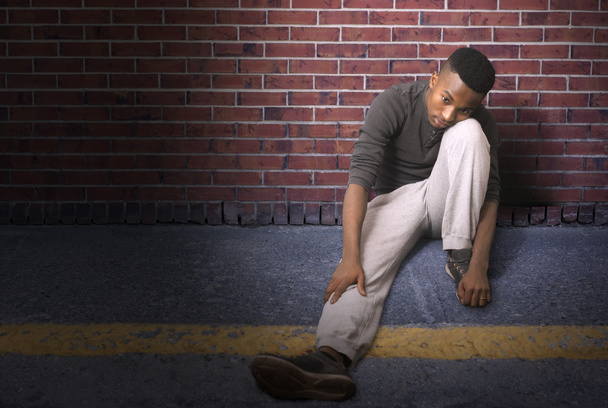 νεαρός άνδρας κάθεται στο έδαφος, τη νύχτα, δρομέας στο διάλειμμα - Φωτογραφία, εικόνα