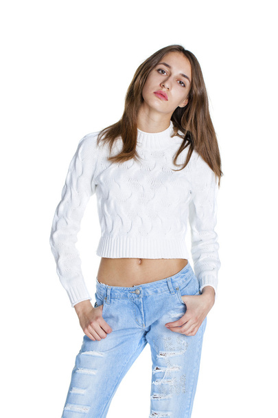 Portrait of a beautiful woman in blue jeans and white sweater - Фото, зображення