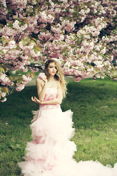 Woman in pink dress near bloom - Foto, immagini
