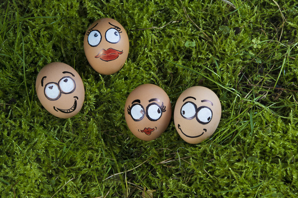 Négy húsvéti tojás arcok, a zöld fű - Fotó, kép