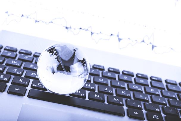 bir dizüstü bilgisayar klavye üzerinde bir cam dünya iş kavramı - Fotoğraf, Görsel