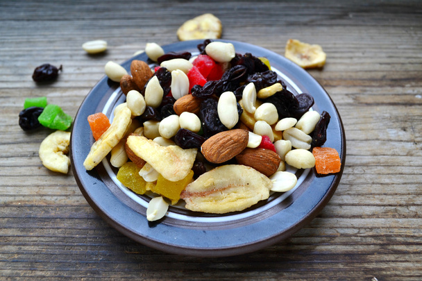 Mischung aus verschiedenen Nüssen und kandierten Früchten auf Holztisch - Foto, Bild