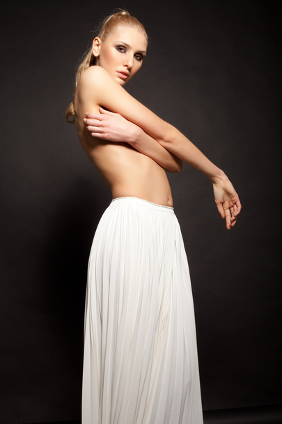 halve naakte blonde vrouw in lange witte rok - Foto, afbeelding
