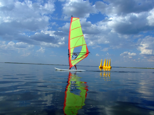 windsurfer en haar reflectie in water o - Foto, afbeelding