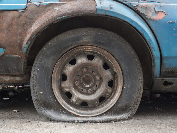 Feche o pneu furado do parque de estacionamento velho na rua à espera de reparação - Foto, Imagem