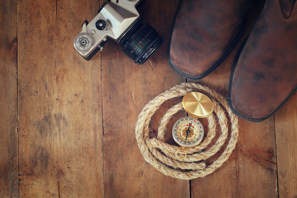 bovenaanzicht van kompas, touw, wandelen laarzen en oude camera - Foto, afbeelding