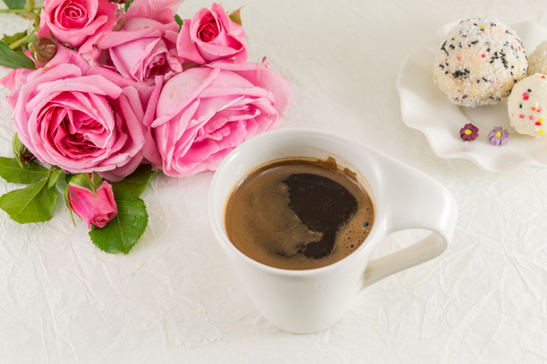 Vaaleanpunaisia ruusuja ja kahvikuppi
 - Valokuva, kuva