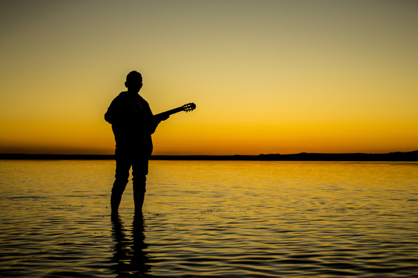 Truthahn, der Salzsee bei Sonnenuntergang Silhouette eines Mannes, der Gitarre spielt Tag - Foto, Bild