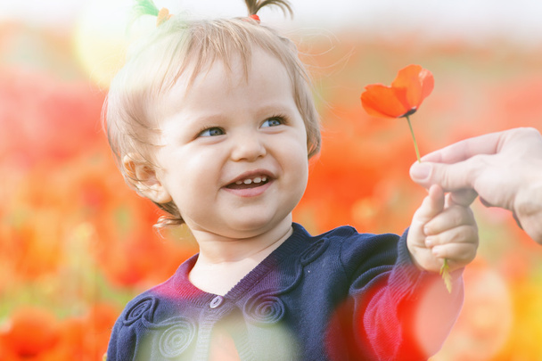Funny child holding a balloon outdoor at poppy field - Foto, Bild