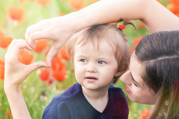 Mother with funny child outdoor at poppy flowers field - Φωτογραφία, εικόνα