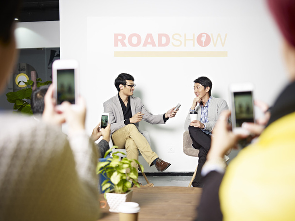 nuori aasialainen yrittäjä haastatellaan aikana roadshow
 - Valokuva, kuva