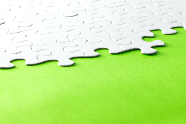 White jigsaw puzzle on green background - Photo, Image