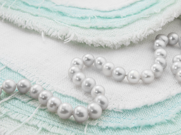 ターコイズ ブルーと白の擦り切れているリネンの白い真珠のネックレスのクローズ アップ - 写真・画像